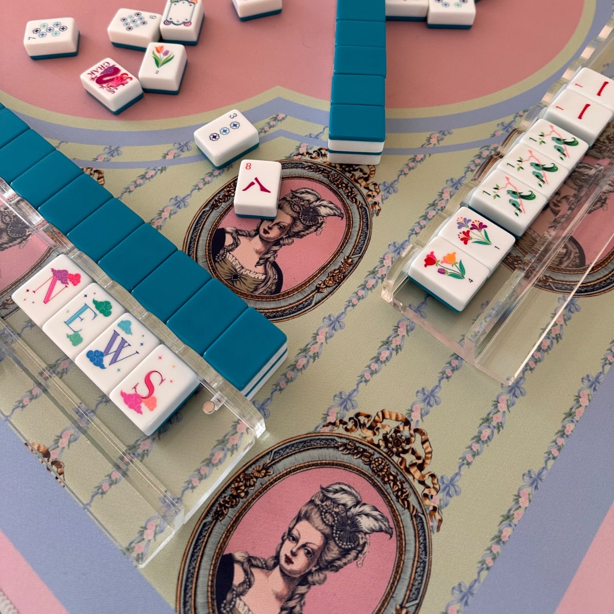 Four Winds Social (Drop 2) Let Them Mahj! mat. 
Mahjong & Co. Celestial tiles.
Humble Oak scallop acrylic racks.